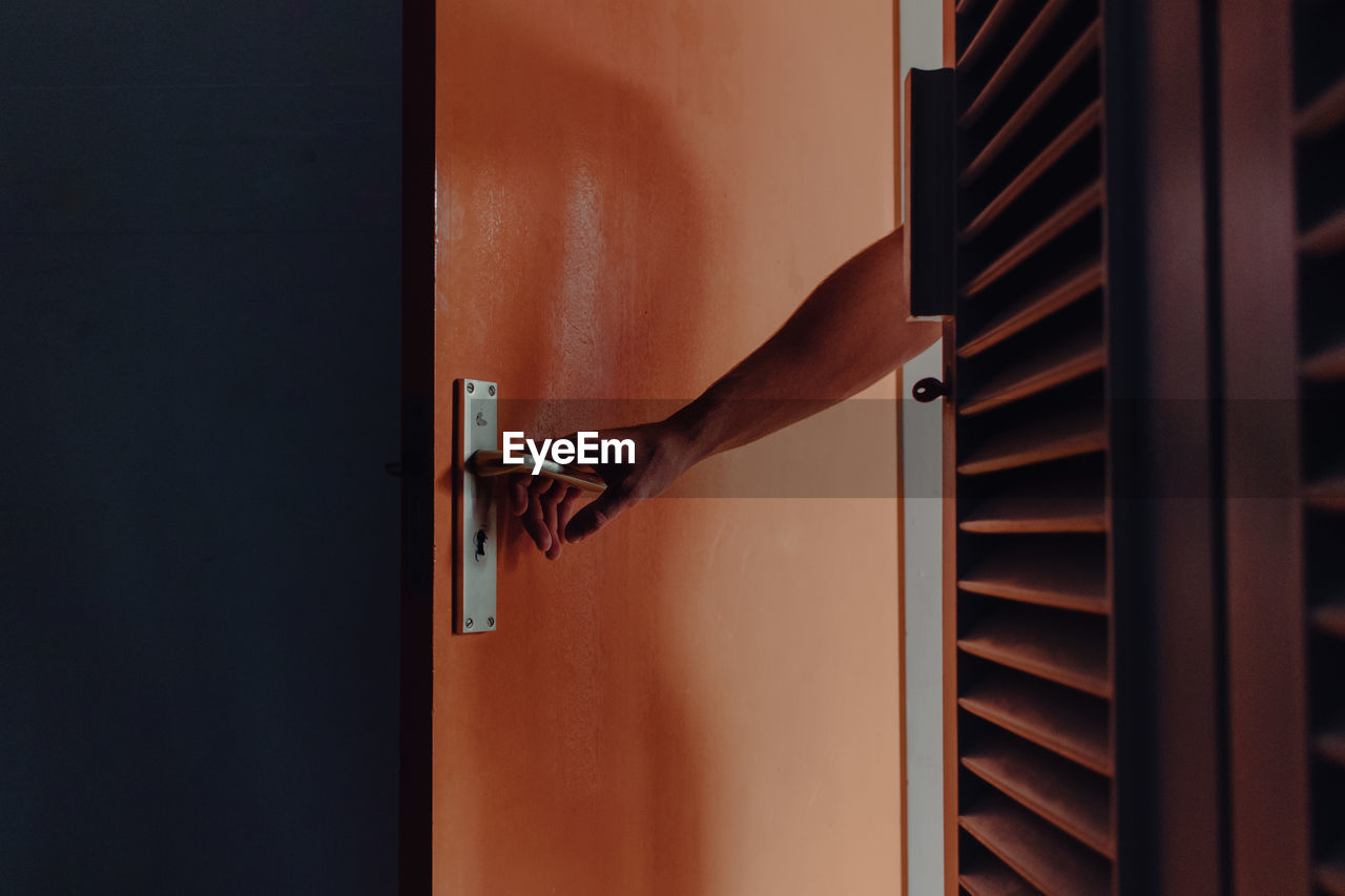 Cropped image of man holding door at home