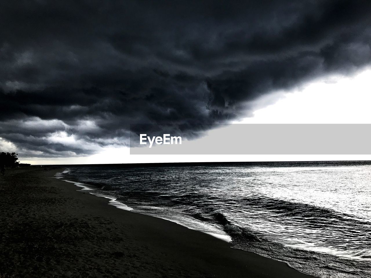 SCENIC VIEW OF BEACH AGAINST STORM CLOUDS