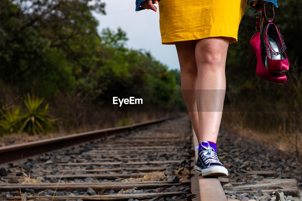 LOW SECTION OF WOMAN WALKING BY RAILROAD TRACKS