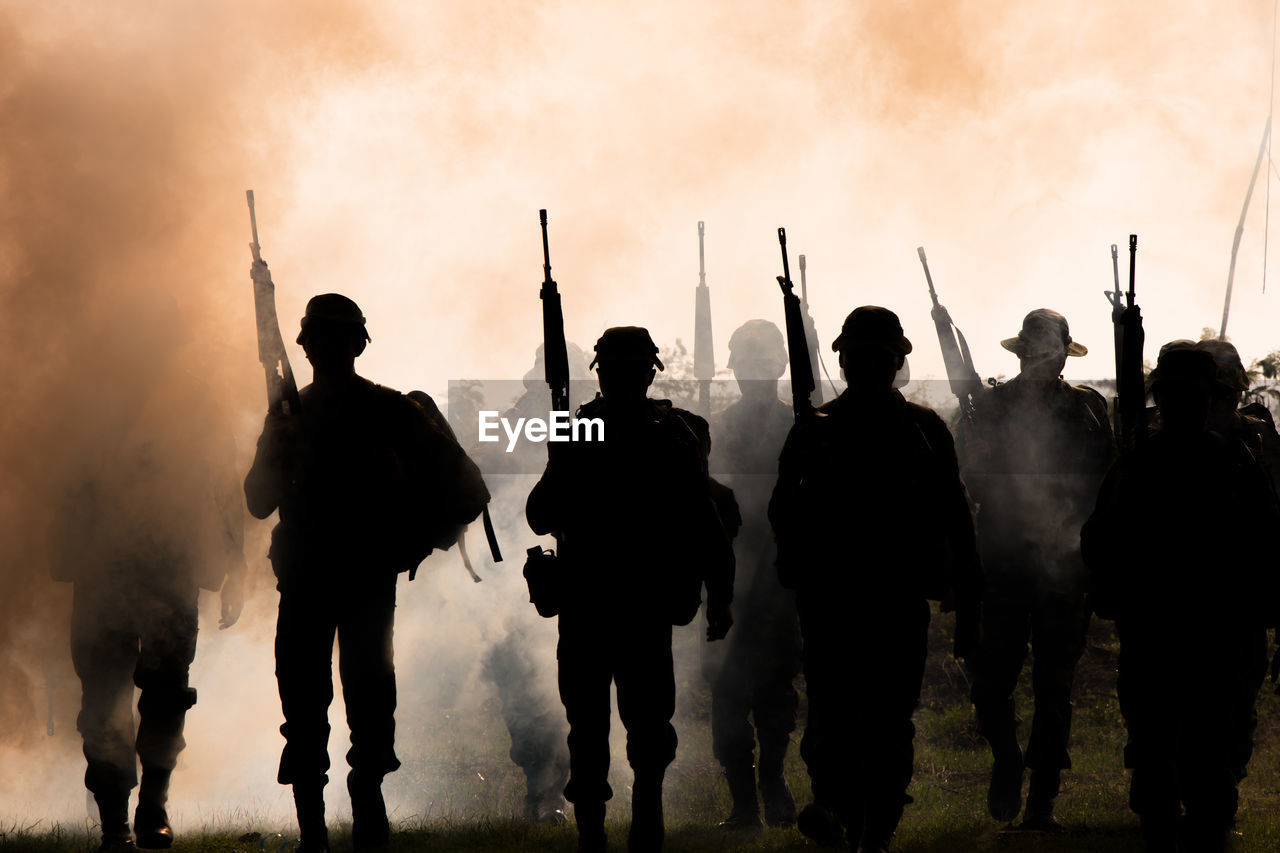Army soldiers walking against smoke