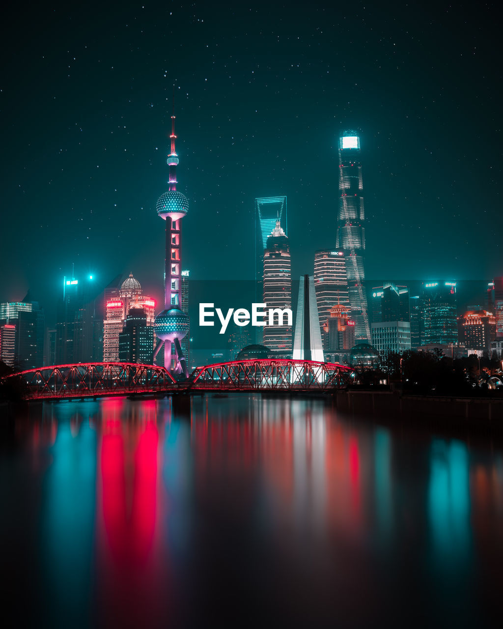 Oriental pearl tower by huangpu river in city at night