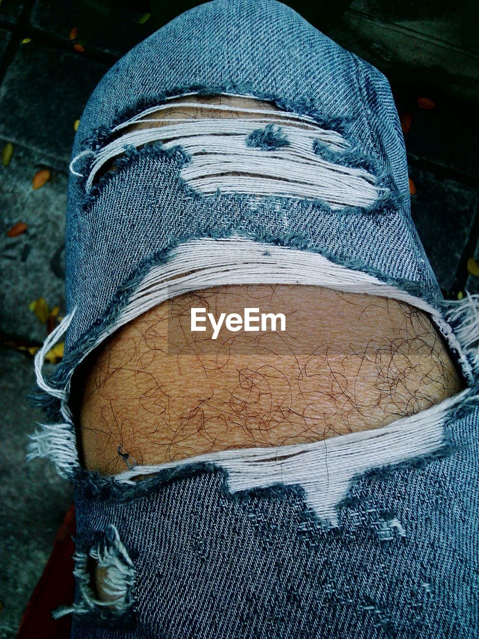 Cropped image of man wearing torn jeans