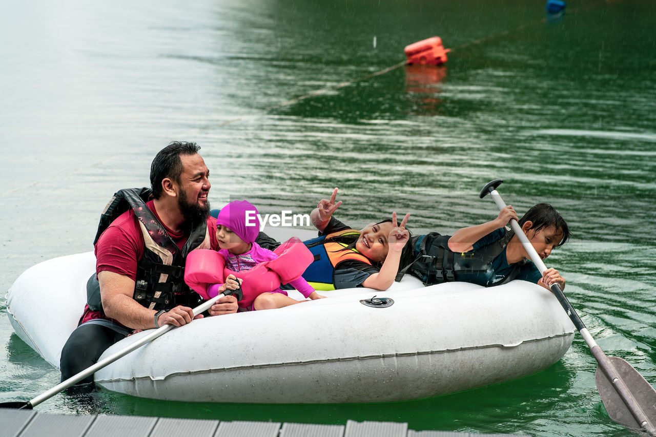 PEOPLE ENJOYING IN BOAT AT LAKE