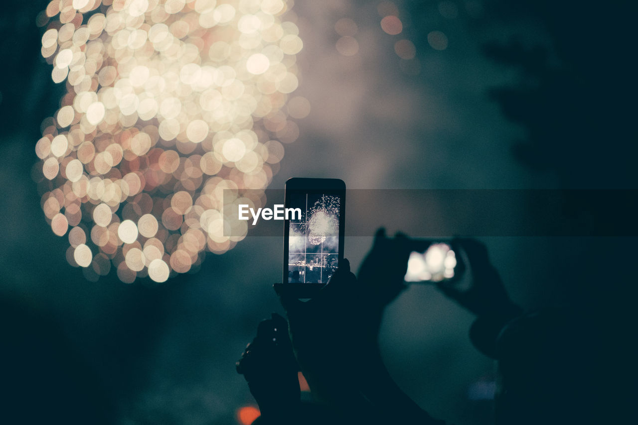 Close-up of hand holding smart phone at night