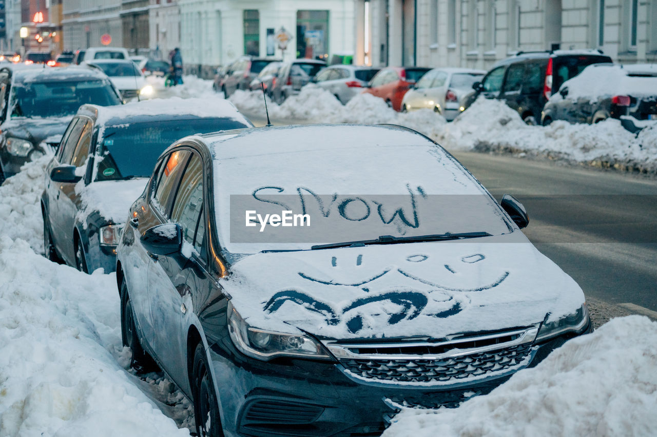 Text on snow covered car in city