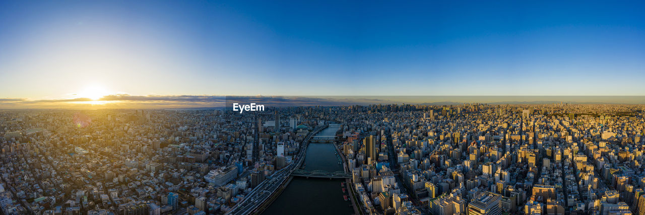 HIGH ANGLE VIEW OF CITYSCAPE AGAINST BLUE SKY