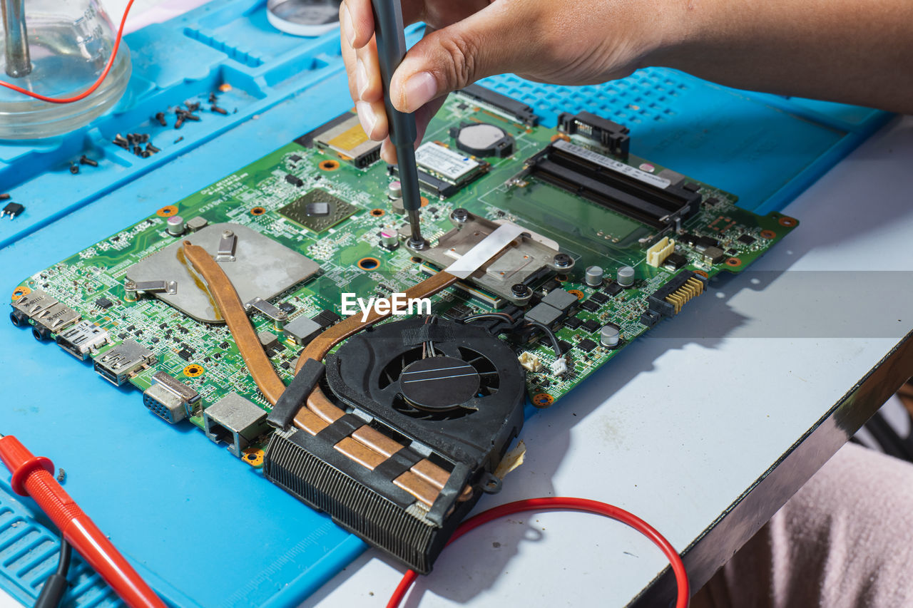 Use a screwdriver to remove the motherboard heat sink for repair.