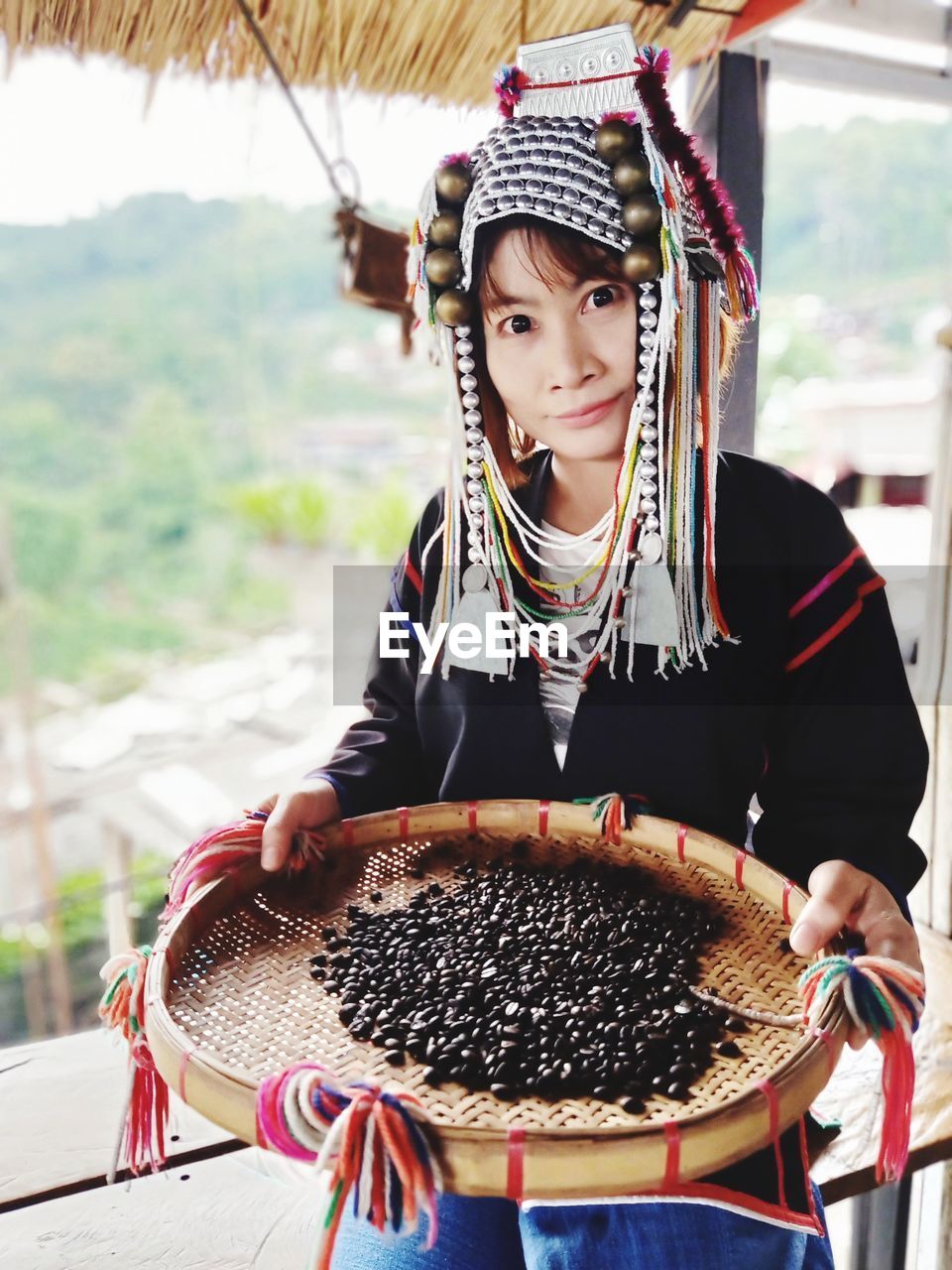 Portrait of woman holding basket with roasted coffee beans