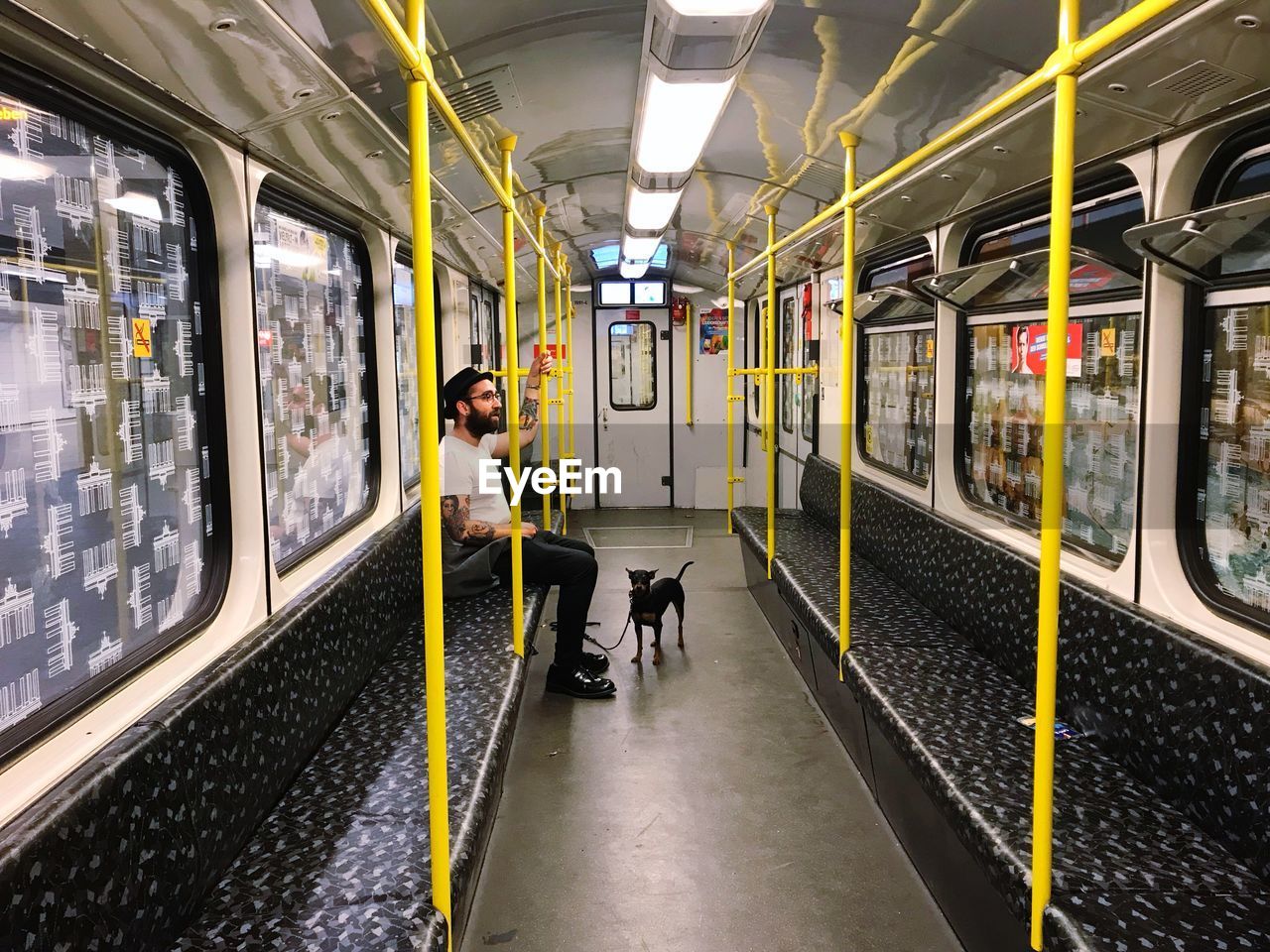 Side view of man traveling with dog in train