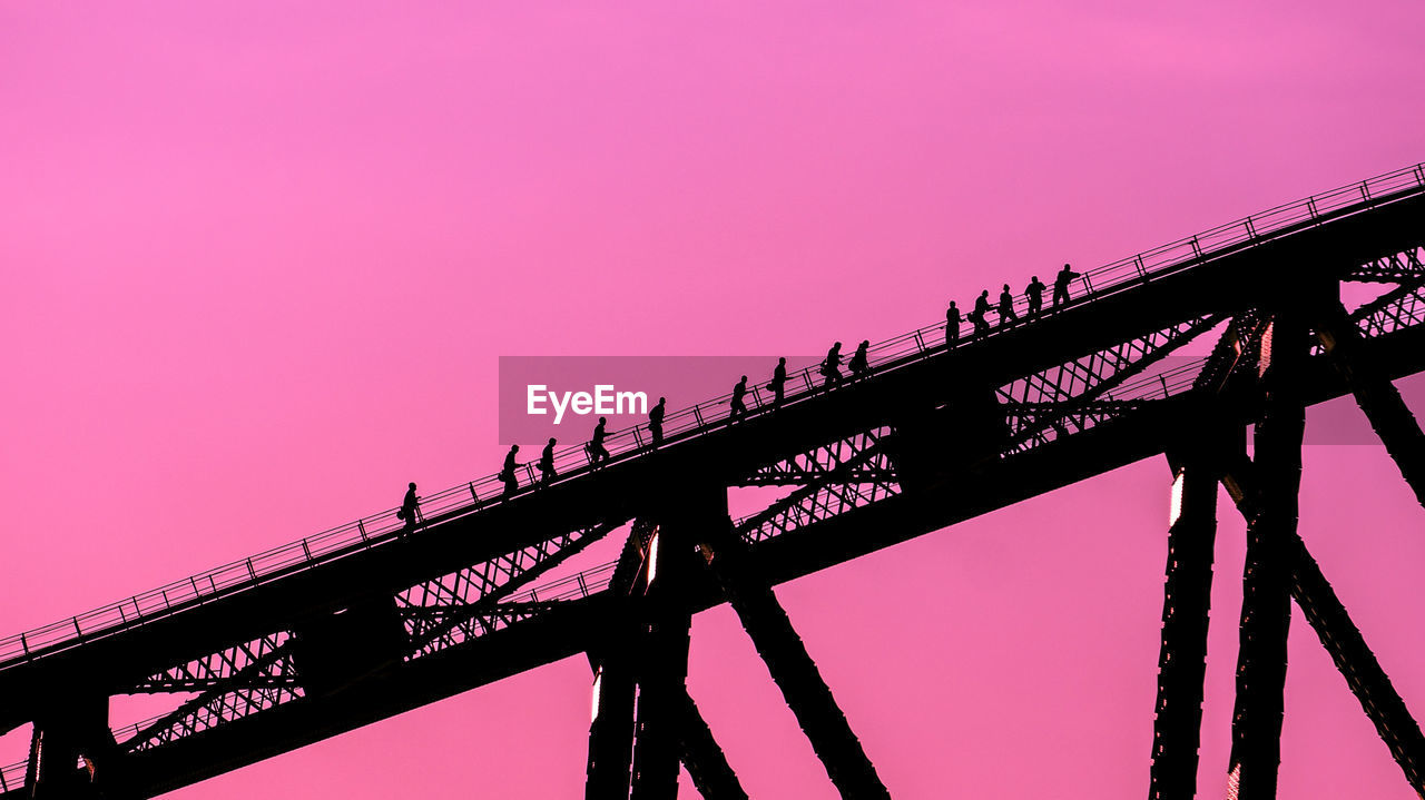 Low angle view of bridge against pink sky
