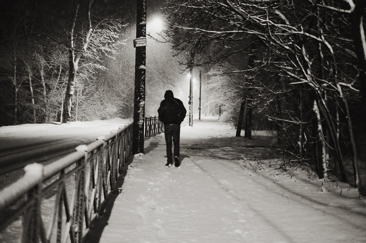 Silhouette man walking on snow covered footpath
