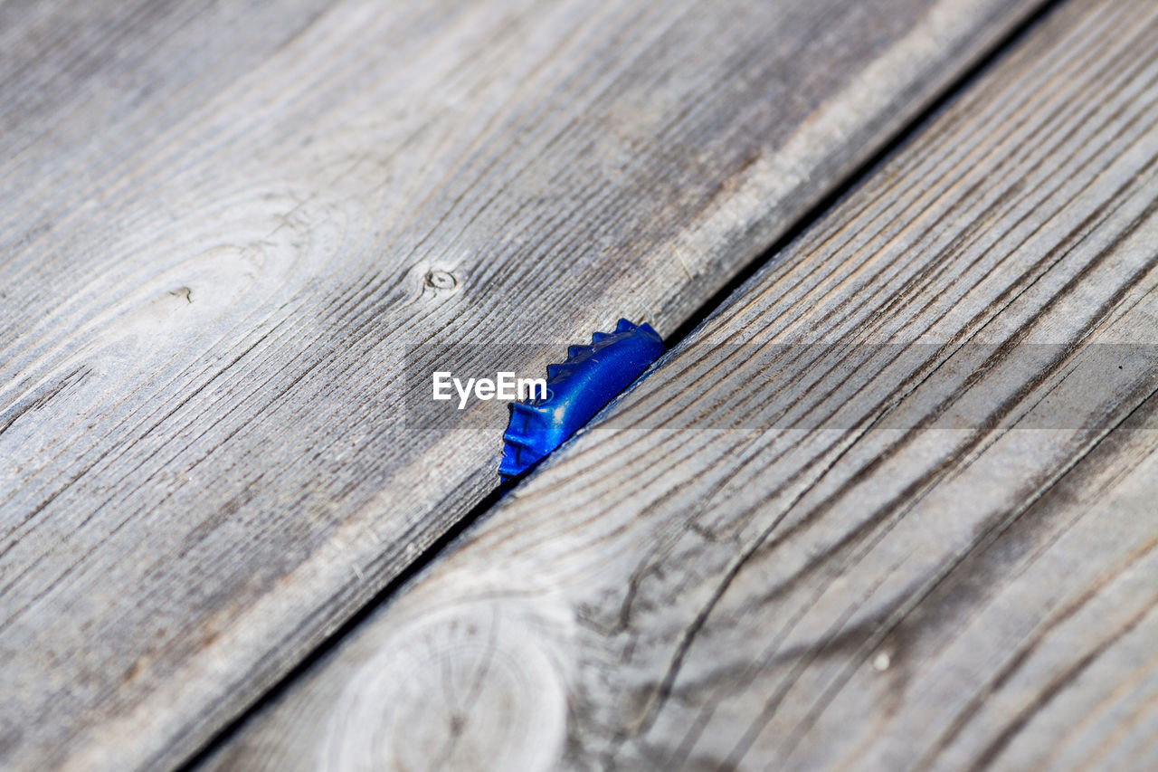 High angle view of blue bottle cap stuck in ID 96605286