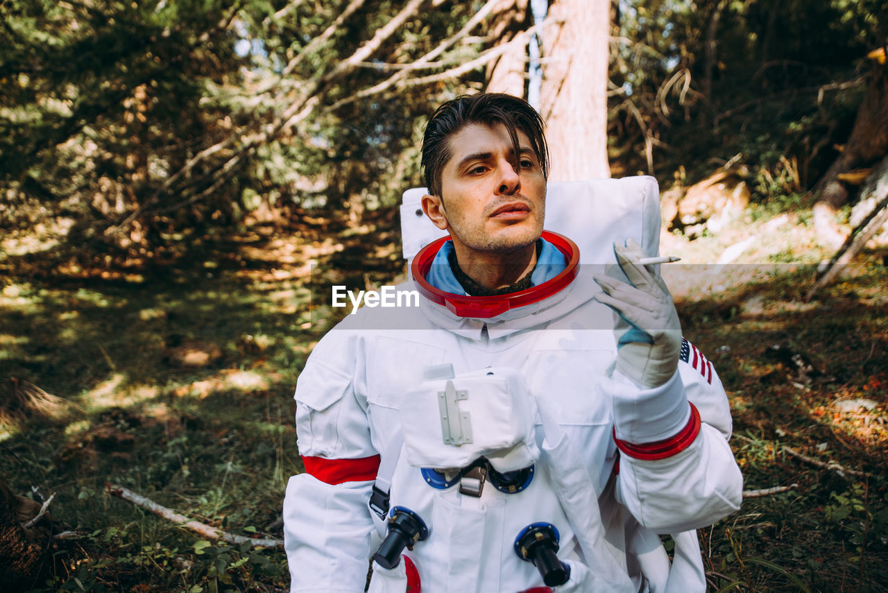 Astronaut smoking in forest