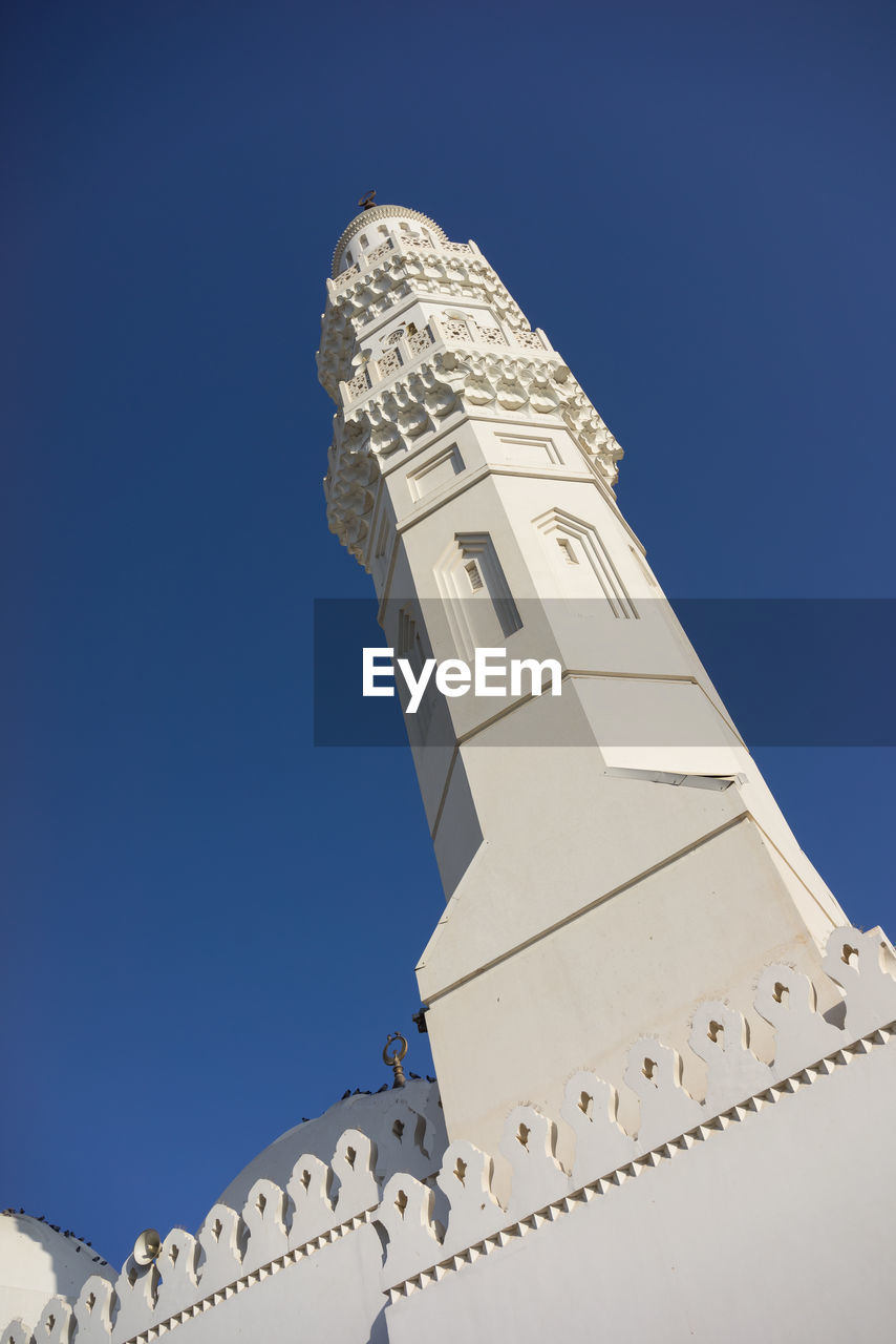 Low angle view of mosque against clear blue sky