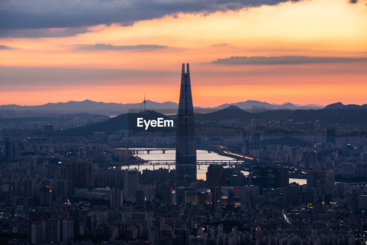 VIEW OF BUILDINGS AGAINST CLOUDY SKY DURING SUNSET