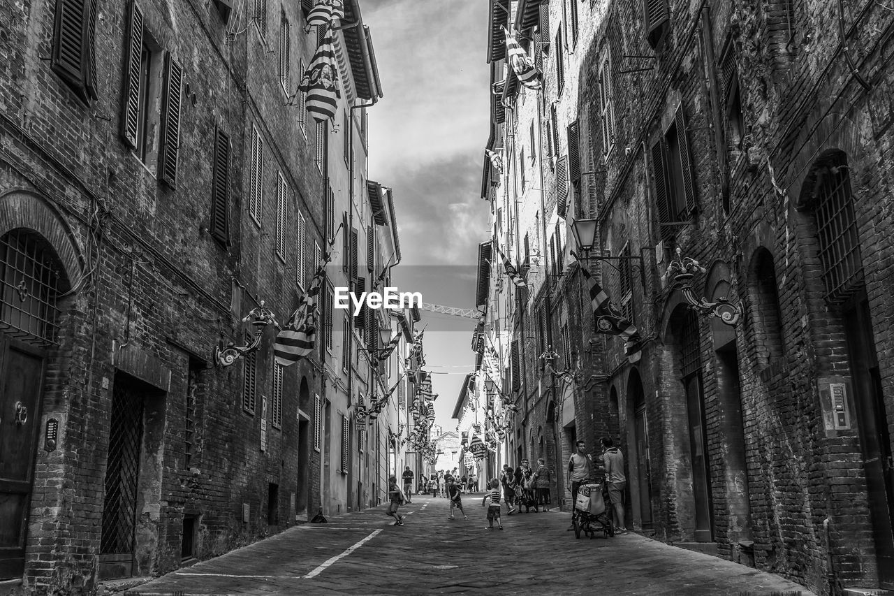 Alley amidst city against sky