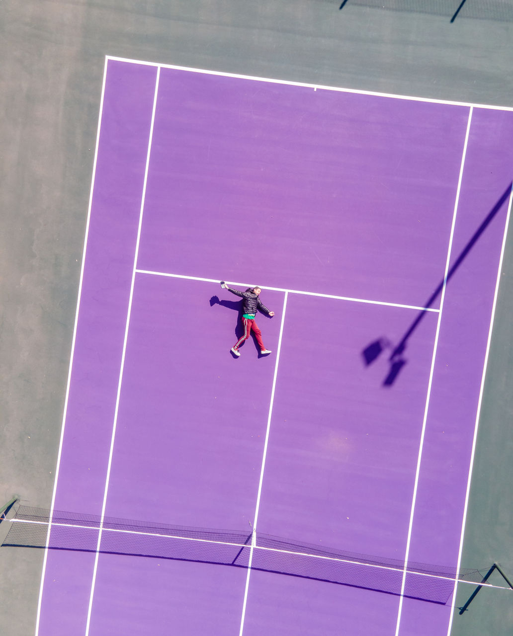 High angle view of man laying on tennis court