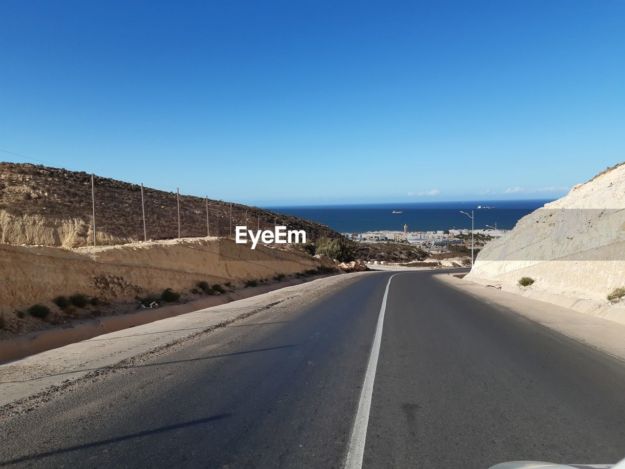 SURFACE LEVEL OF ROAD AGAINST BLUE SKY