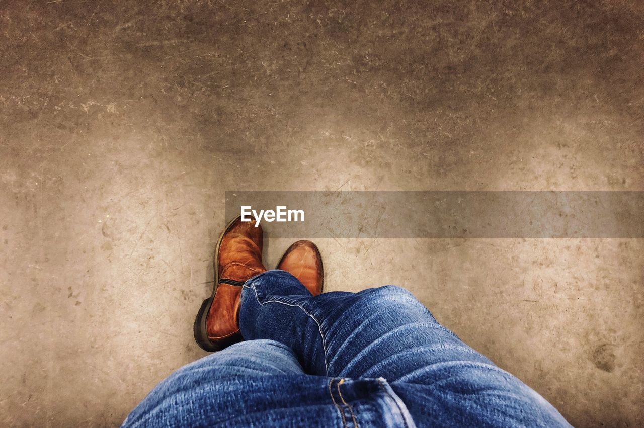 LOW SECTION OF MAN STANDING ON CARPET