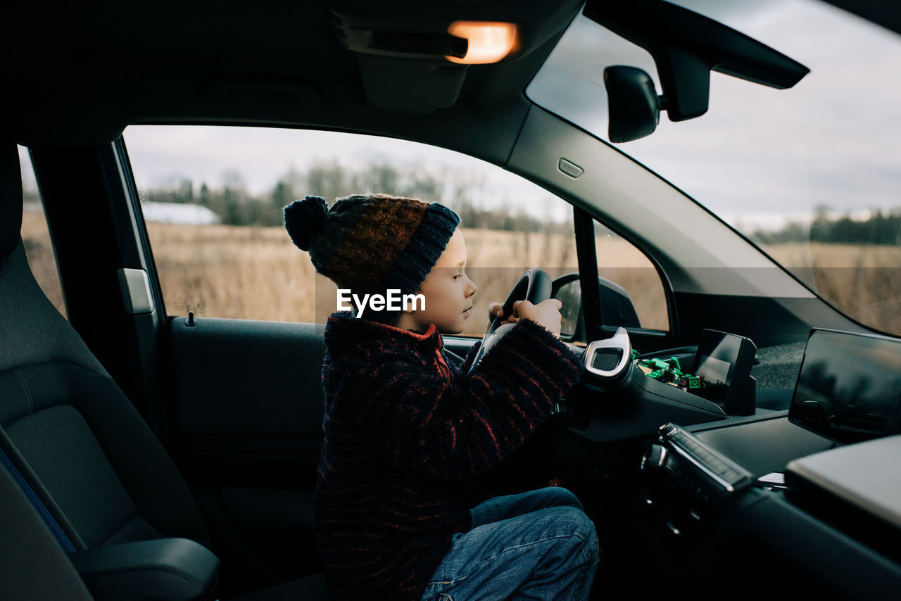 REFLECTION OF BOY SITTING IN CAR