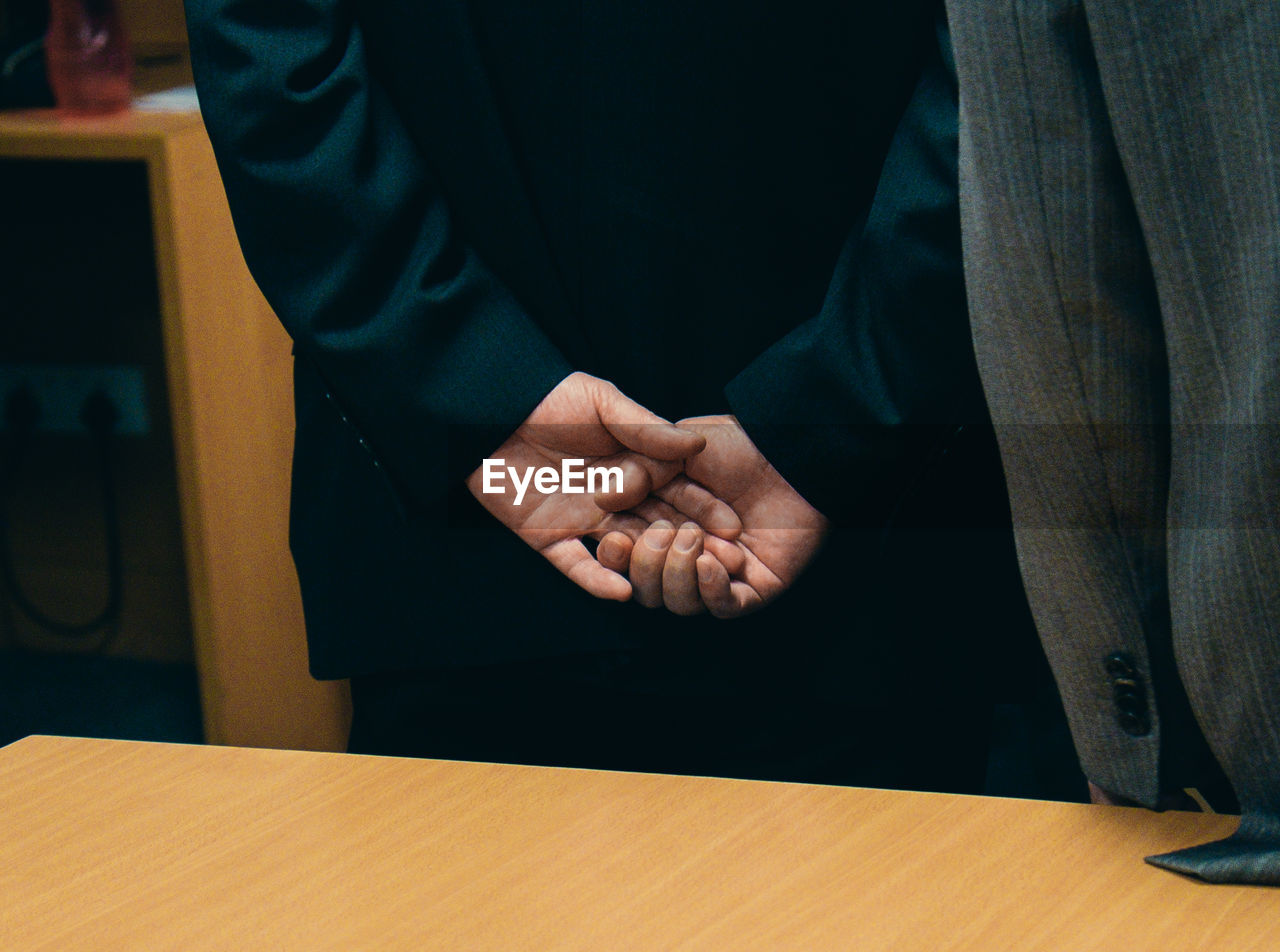 Cropped image of businessmen shaking hands in office