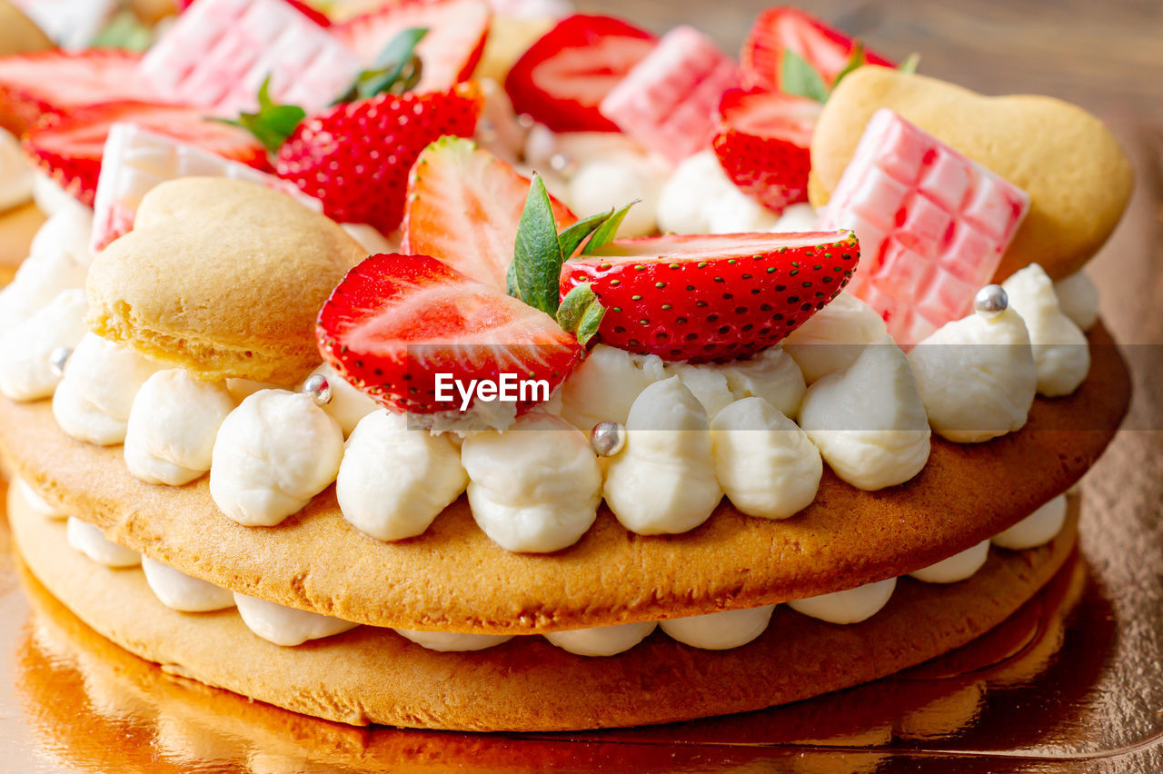 Sponge cake with strawberries, pink milk chocolate bars, silver sprinkles, vanilla cream 