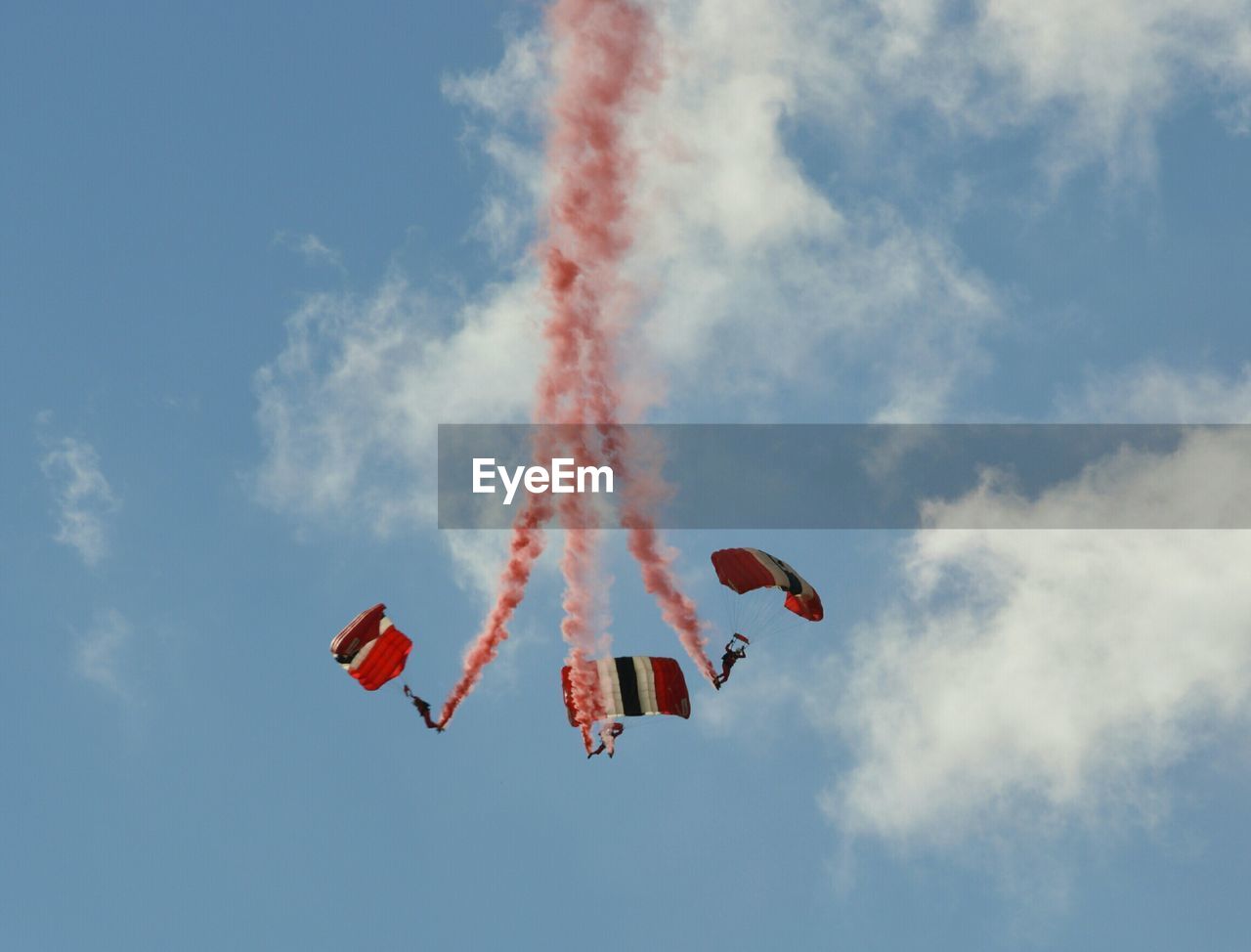 Low angle view of people performing aerobatics against sky