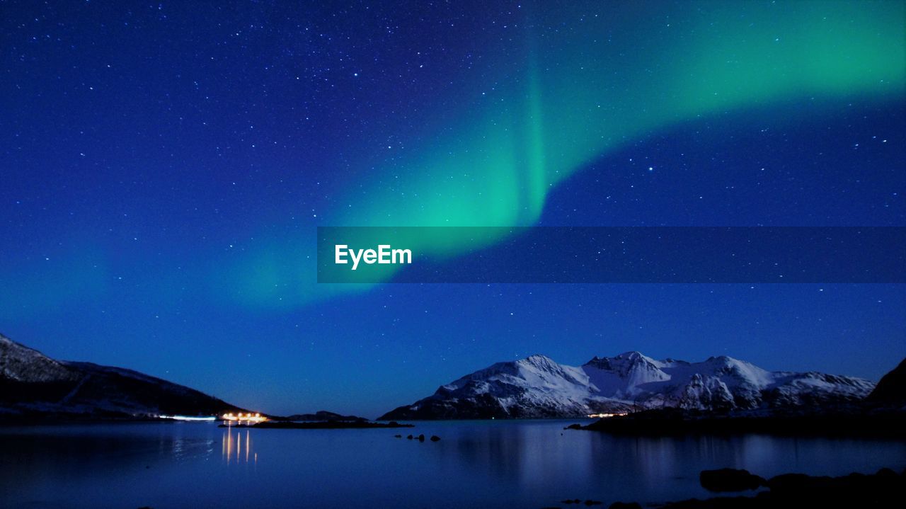Scenic view of snowcapped mountains and northern lights against sky at night