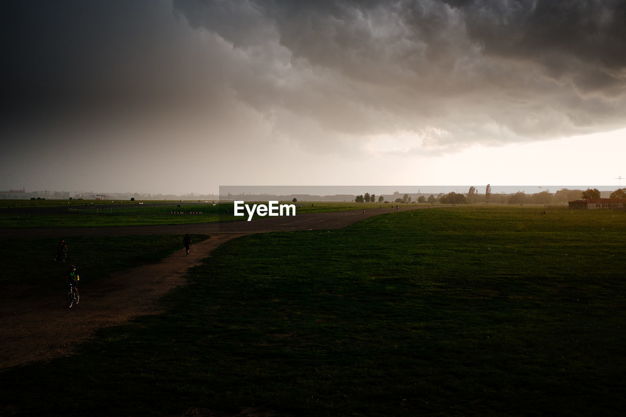Scenic view of grassy field against cloudy sky
