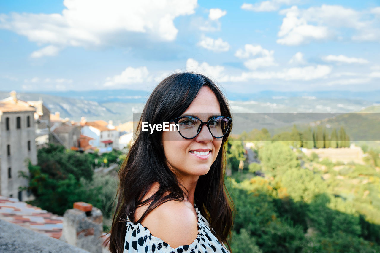 Portrait of a beautiful young woman with eyeglasses. nature, landscape in background.