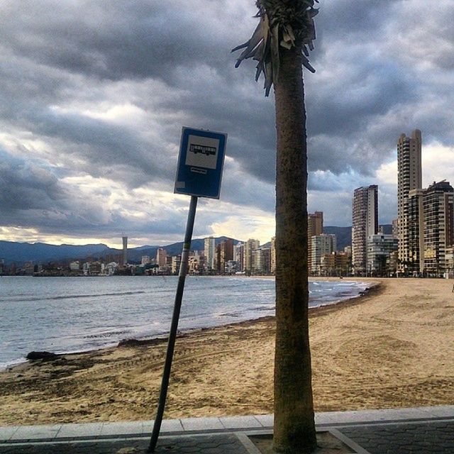 INFORMATION SIGN ON BEACH AGAINST SKY IN CITY