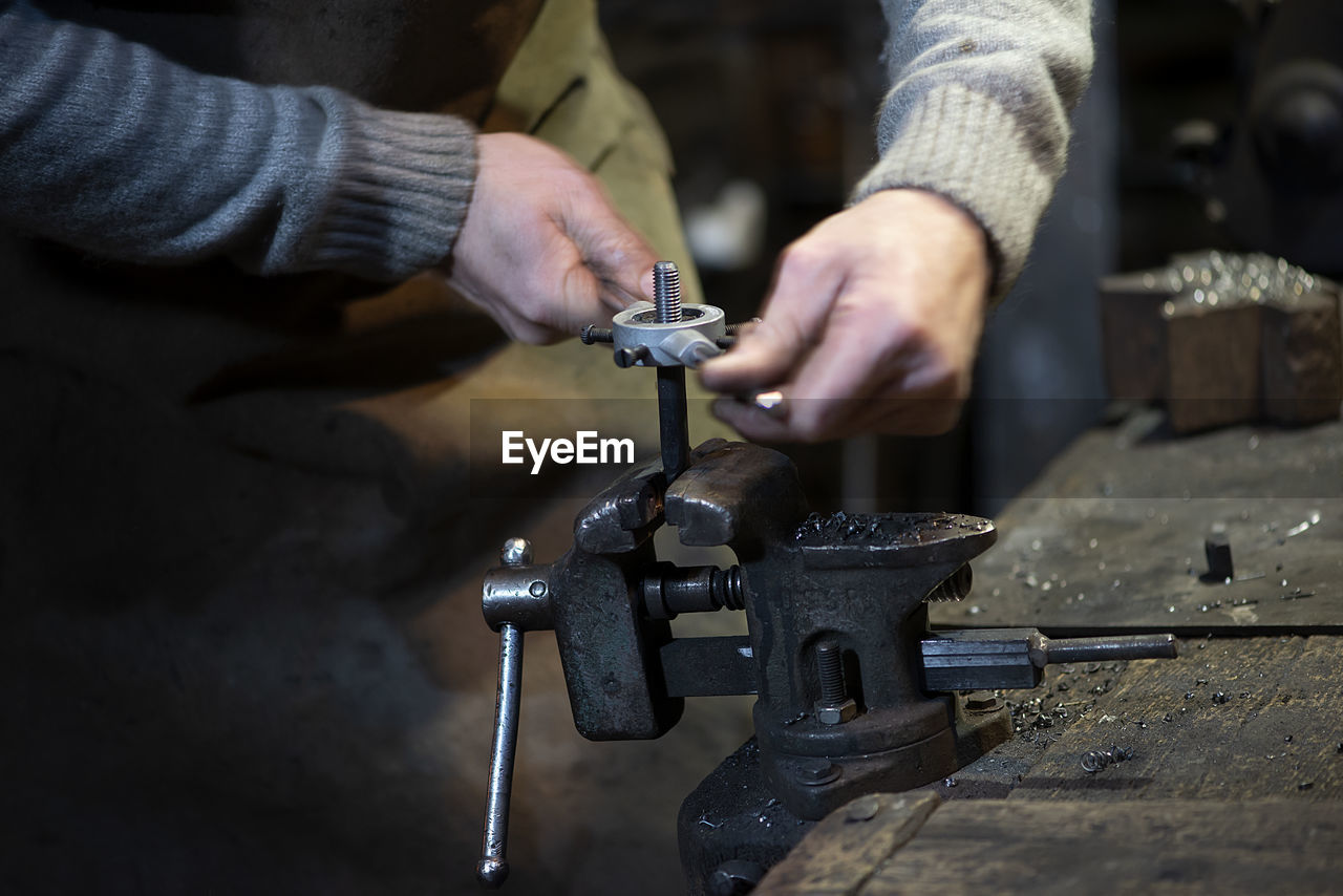 Professional blacksmith working with metal at forge.handmade, craftsmanship , blacksmithing concept