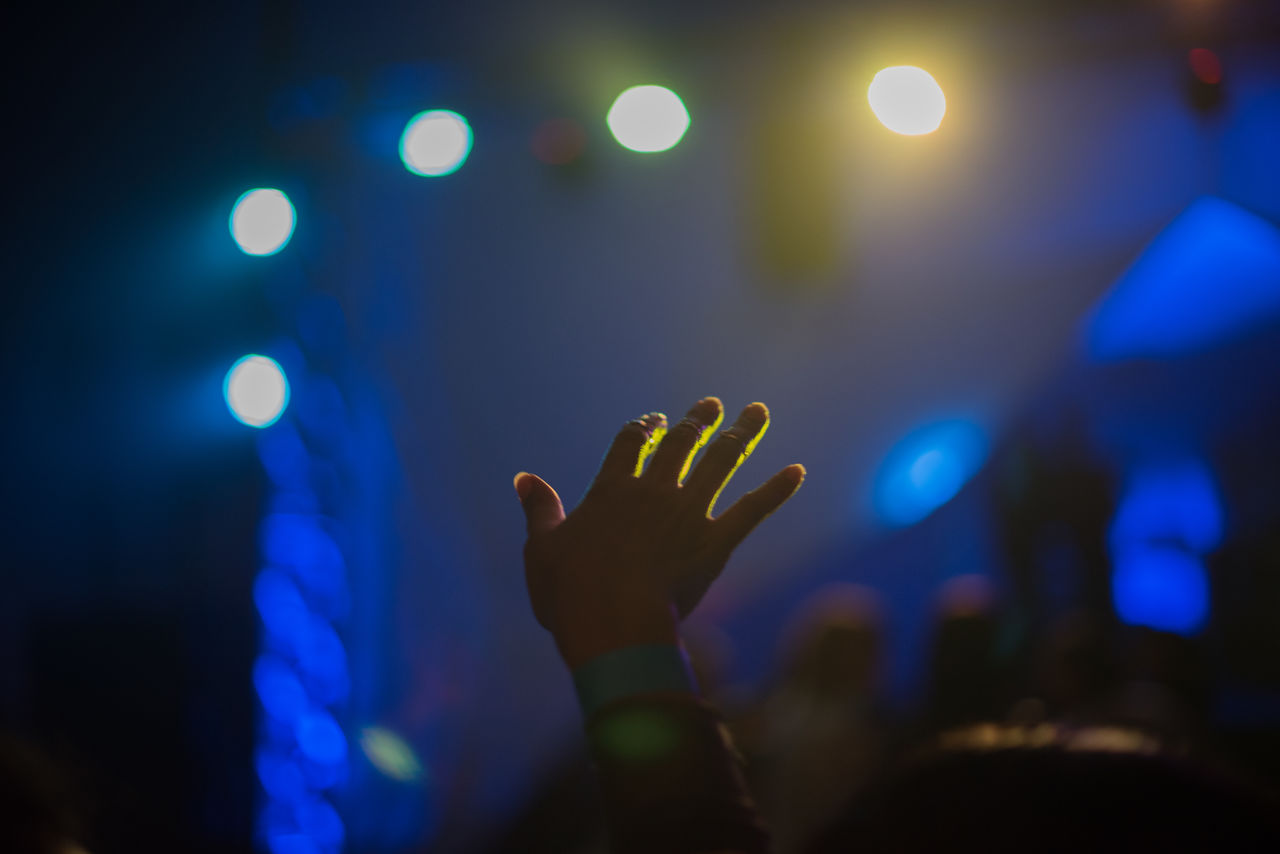 Cropped hand of woman in illuminated music concert