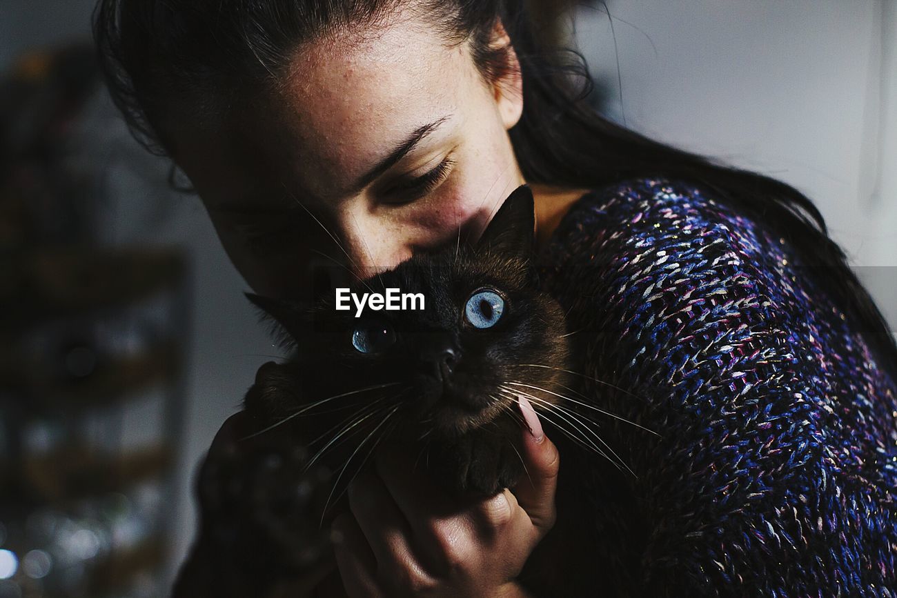 Close Up Of Young Woman Holding Cat At Home Id 121599822