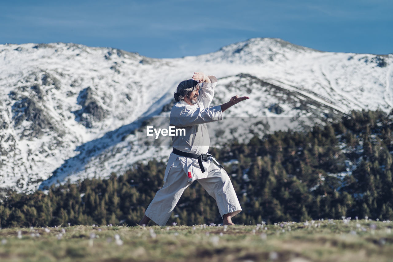 Senior man practicing karate outdoors