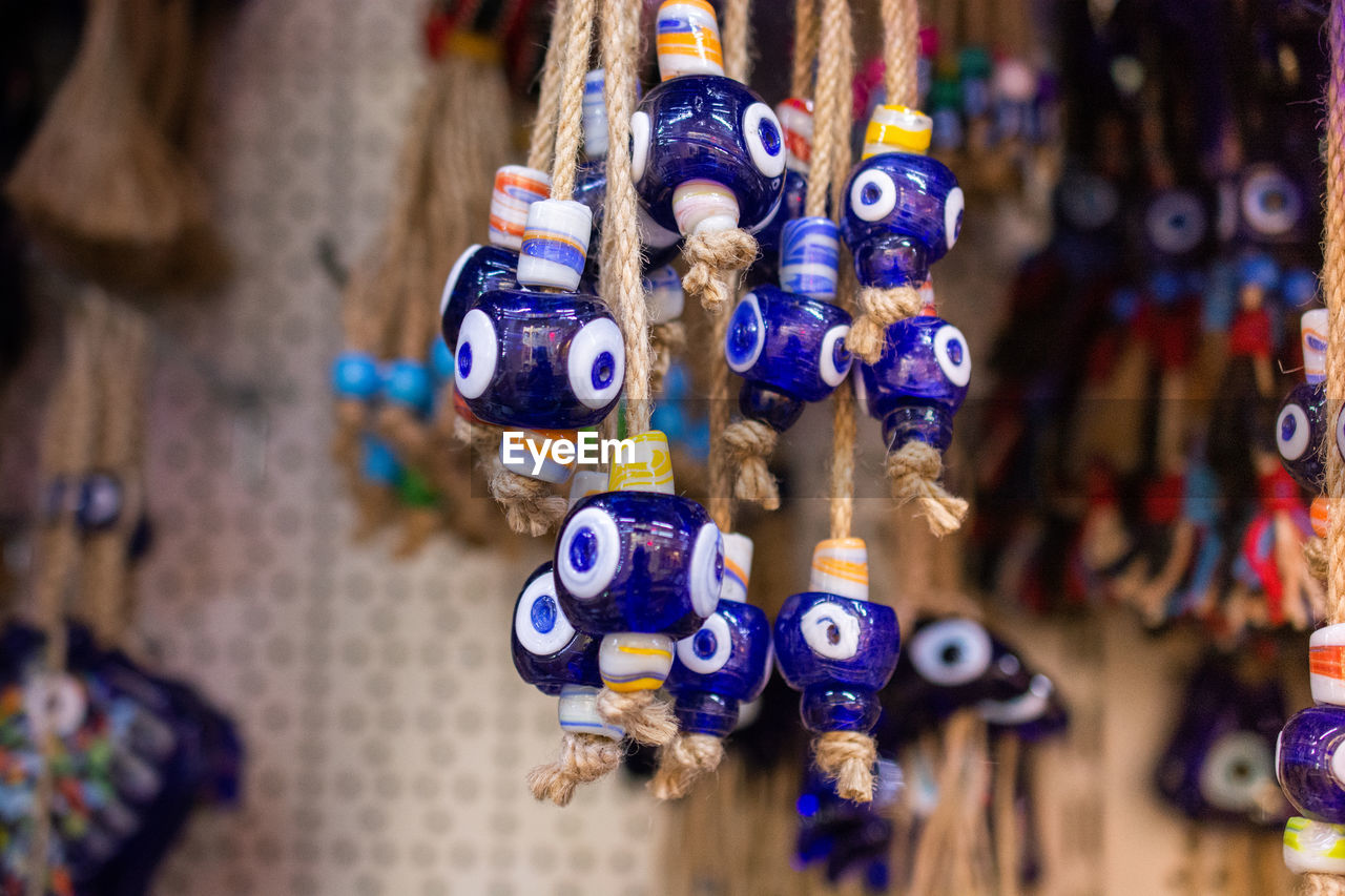 CLOSE-UP OF DECORATIONS HANGING FOR SALE