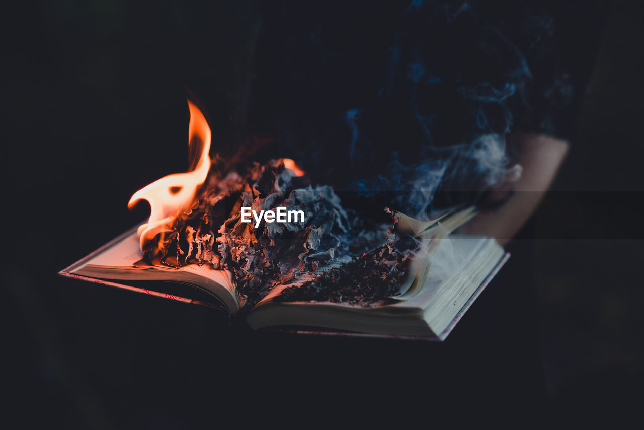 Burning book against black background