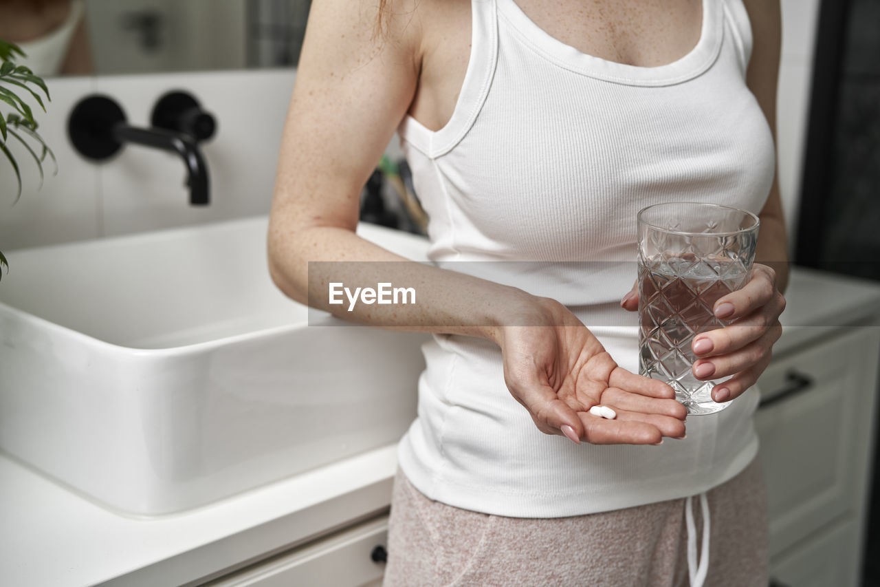 Midsection of woman washing hands in bathroom
