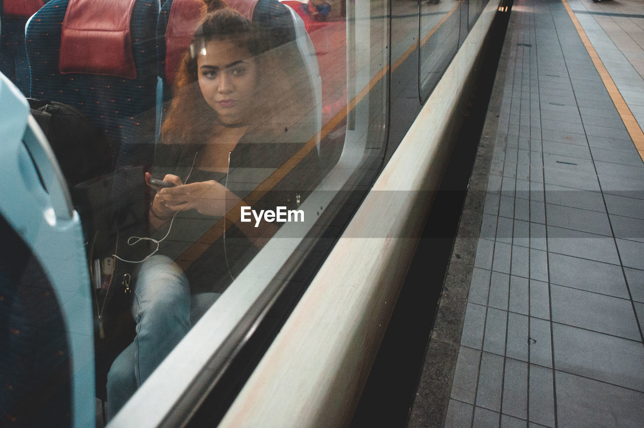 Woman sitting in train seen through window