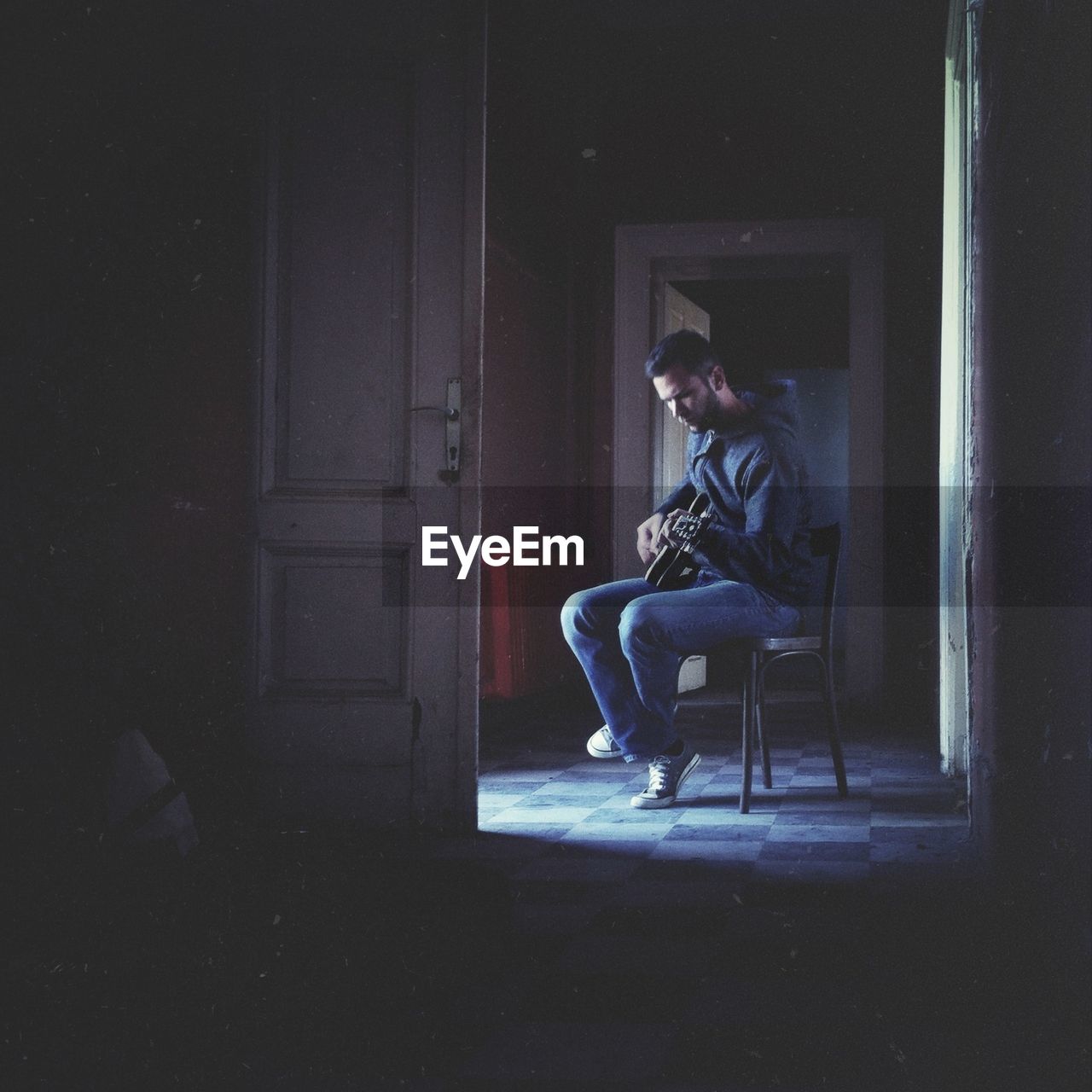 Man playing the guitar in dark room