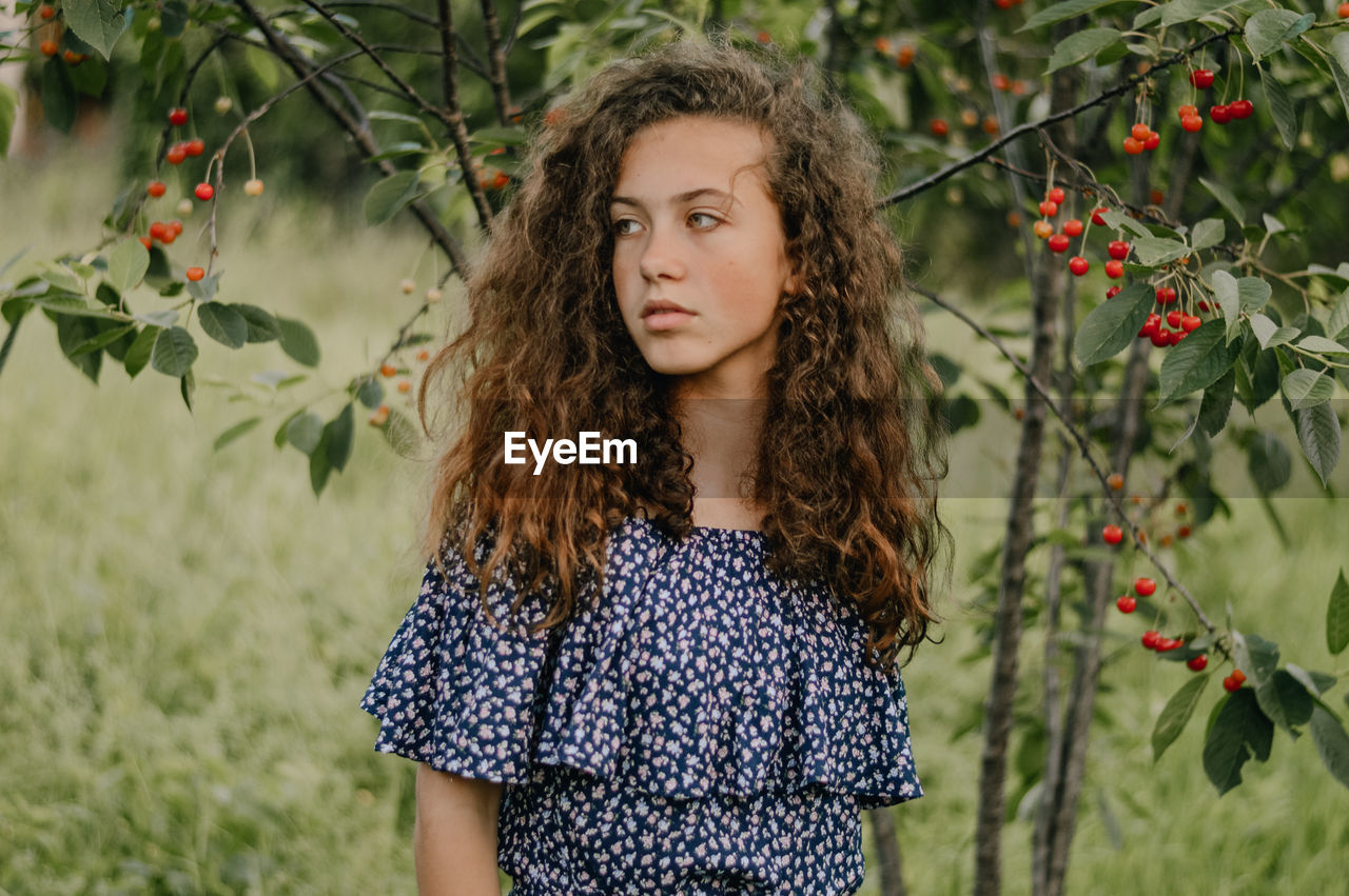 Portrait of teenage girl standing against plants