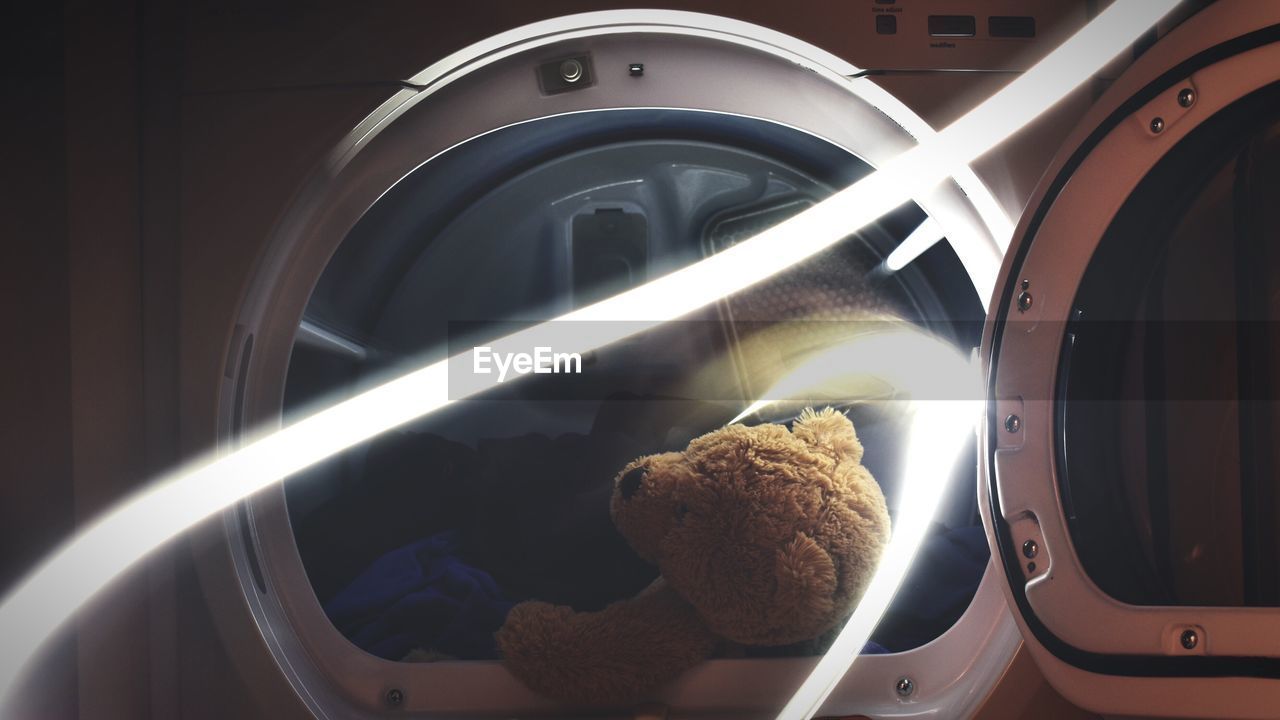 Close-up of teddy bear in washing machine by light painting