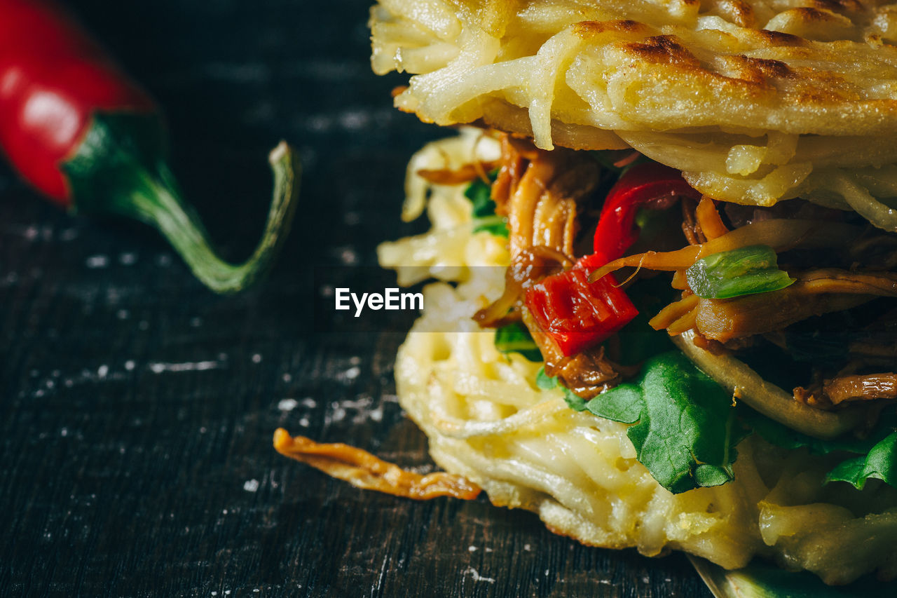 Cropped image of fresh ramen burger with red chili pepper