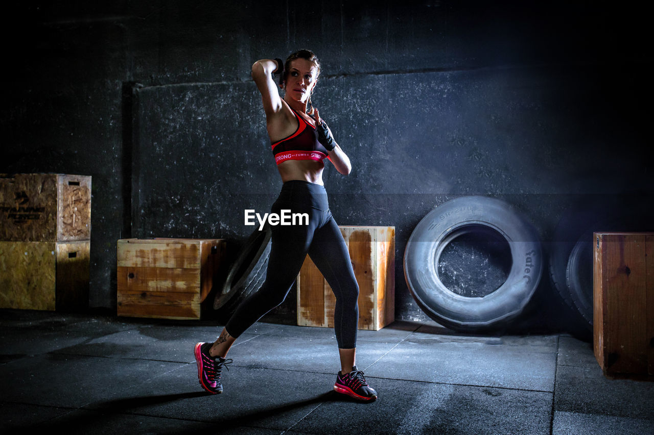 Woman with arms raised practicing aero box, strong by zumba