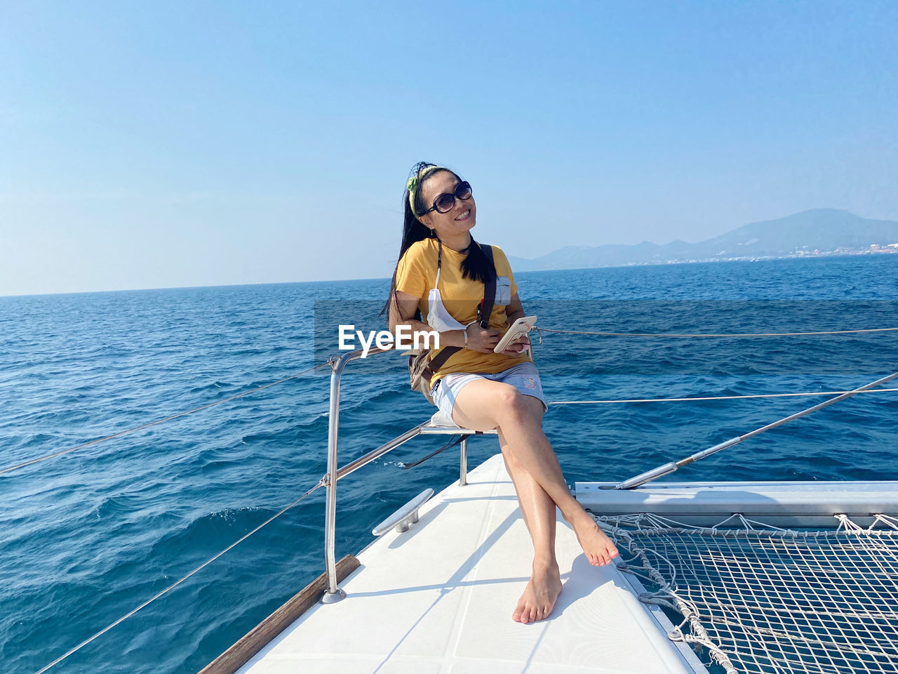 Young woman wearing sunglasses on sea against sky