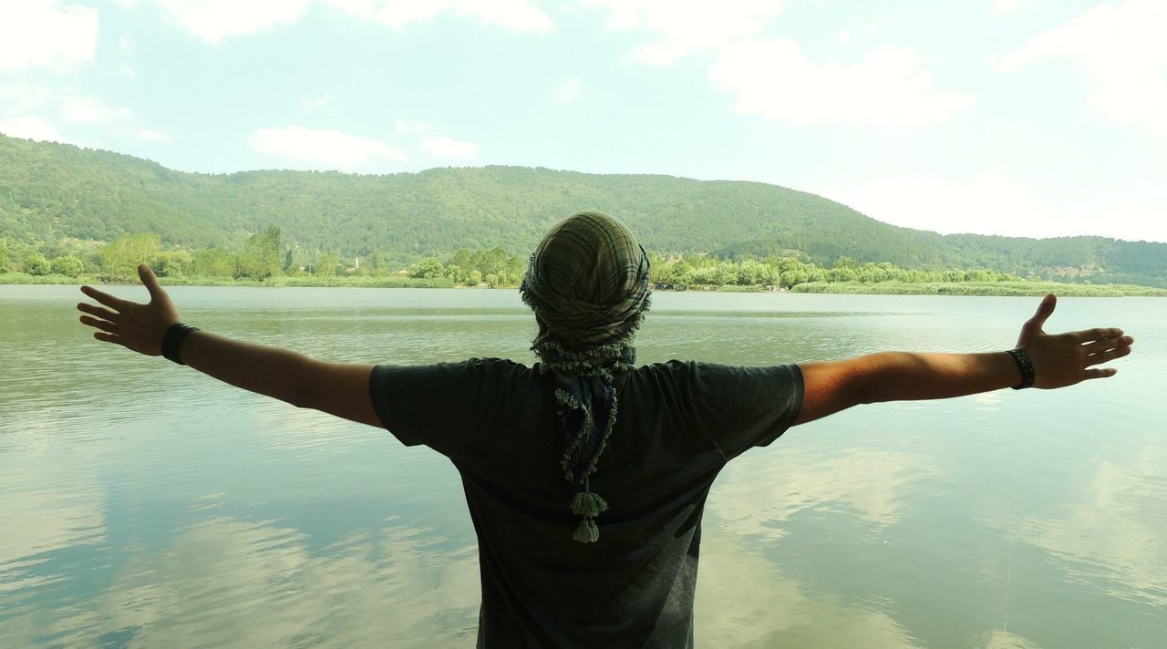 Rear view of man looking at lake