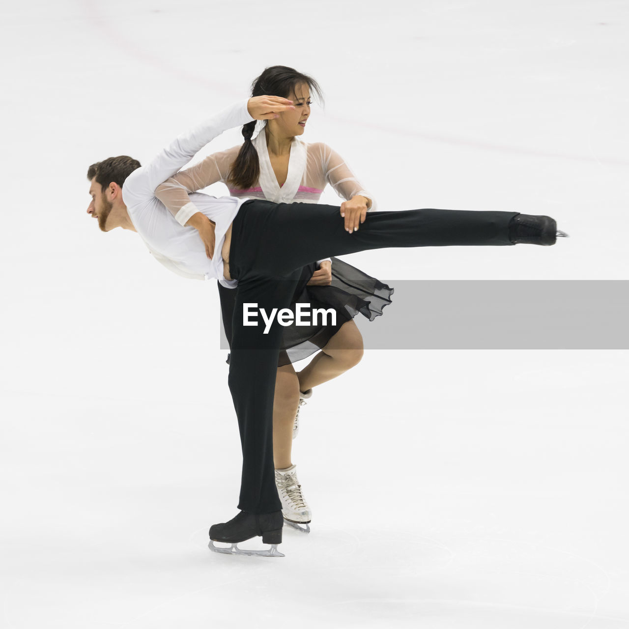 Man and woman performing during figure skating against white background