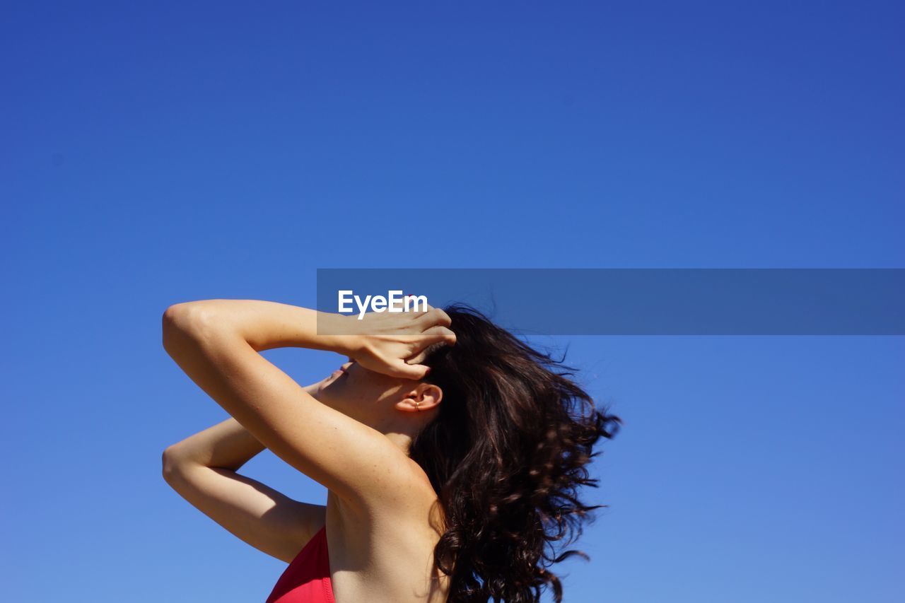 Portrait of woman against blue sky