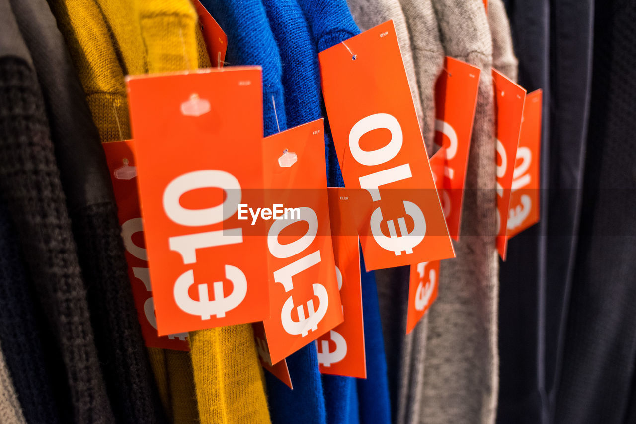 Close-up of information sign on clothes for sale in market