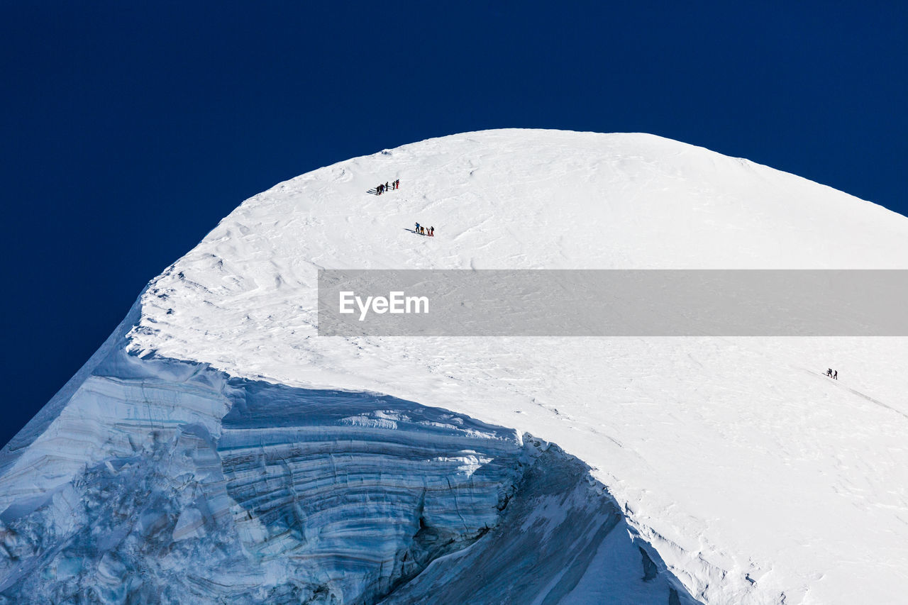 Aerial view of snowcapped mountain against blue sky. view from klein matterhorn, swiss alps